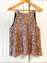 Musculosa dorada con lentejuelas y tirantes finos.