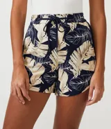 Short runner de viscosa con estampado de hojas en tonos beige y negro. Tiene cintura elástica con cordón ajustable, dos bolsillos laterales y dobladillo redondeado.