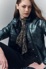 Camisa entallada de cuero ovino verde metalizado, con cuello camisero y botones a presión con logo.