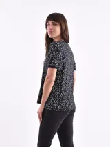 Remera negra con estampado de estrellas blancas y texto amarillo.