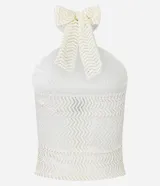 Top blanco de tejido texturado con patrón de zigzag, estilo halter con cuello anudado en la espalda y detalle de argolla metálica dorada en el centro del escote.