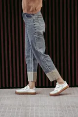 Zapatillas urbanas blancas con detalles en gris y suela color caramelo. Presentan cierre con tiras de velcro.