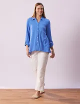 Camisa celeste de textura arrugada, con cuello clásico, cierre frontal con botones y mangas 3/4 con trabilla.