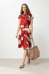 Vestido camisero color beige con estampado abstracto de flores rojas y marrones, de manga corta y largo a la rodilla. Incluye cinturón de la misma tela.