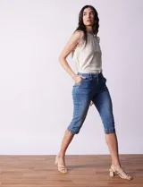 Pantalón capri blanco de algodón elastizado. Pretina con pasadores, botón y cierre. Delantera con bolsillos. Trasera con bolsillos simulados.