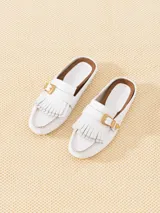 Mocasín mule blanco de cuero vacuno flor, con detalle de flecos en la capellada y hebilla metálica dorada.