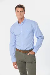 Camisa celeste a cuadros con cuello abotonado, manga larga, bolsillo en el pecho y logo bordado.