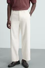 Pantalón de vestir color blanco hueso, de corte relajado (relaxed fit) y tejido de algodón con textura espiga. Presenta bolsillos frontales, bolsillo cerillero y bolsillos traseros de vivo.