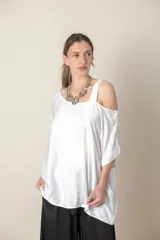 Blusa italiana gris de viscosa, lisa, con corte irregular y un hombro descubierto. De calce holgado.