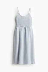 Vestido midi celeste con textura a rayas, cuerpo entallado fruncido, escote redondo y breteles spaghetti. Costura fruncida en la cintura y pollera con leve vuelo.