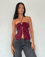 Top halter color bordó con estampado floral, argolla en el cuello y abertura en el frente.