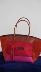 Bolso de fin de semana tipo tote bag, confeccionado en lona y gamuza, con detalles en cuero color marrón. Tiene un bolsillo interno con cierre.