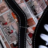 Zapatillas altas negras con diseño gráfico colorido en el lateral, ideales para un look urbano.