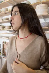 Blusa de punto color beige, de corte recto y escote en V con detalle de nudo.