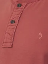 Remera celeste con cuello henley y tapeta con tres botones de madera.