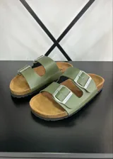 Sandalias de ecocuero color verde oliva con dos tiras ajustables con hebillas plateadas y plantilla anatómica de corcho.