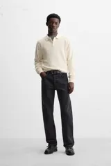 Polo marrón de punto con hilatura de algodón, corte relaxed fit, cuello solapa con cierre frontal de botonadura, manga larga y acabados en rib.