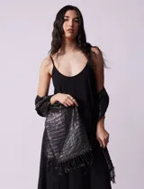Pashmina negra plisada con detalles de lurex plateado y flecos en los extremos.