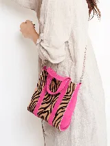 Bolso tipo tote con estampado de cebra en tonos marrones y negros, detalles en color fucsia y correa de cadena metálica.