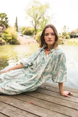 Vestido camisero con estampado floral en tonos celeste y blanco, cuello a la base, manga al codo y botones al frente.