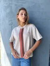 Buzo color beige con rayas verticales marrones, tejido en hilo, de mangas cortas y cuello redondo.