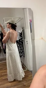 Vestido largo de algodón color blanco con estampado de lunares pequeños en color marrón. Presenta tirantes finos y escote pronunciado en la espalda. El ruedo tiene un volante con fruncido.