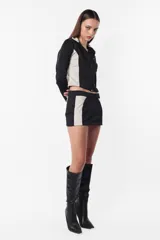 Campera deportiva negra con recortes grises en mangas y laterales. Cierre frontal y calce slim fit. Estampa de logo a tono en el recorte delantero.