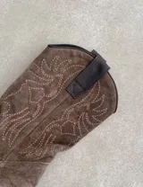 Botas de cuero negro con bordado decorativo en el caño y empeine, taco bajo y punta fina. Diseño de estilo cowboy.