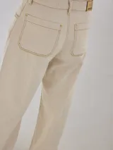 Pantalón gris de tiro medio alto, corte ancho, con bolsillos delanteros y traseros, detalles de atraques y triples costuras en color amarillo.