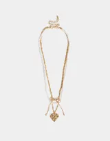 Collar dorado de tres capas: una de perlas, una de cadena de eslabones y una de cadena retorcida con dije de corazón con rosa grabada y moño.