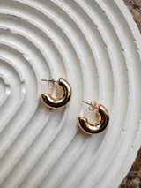 Semi aro pequeño de 2 cm, disponible en tonos dorado y plateado, con diseño simple y elegante.