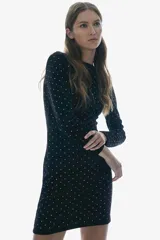 Vestido corto negro de terciopelo con escote barco y mangas largas. Presenta apliques de strass plateados en todo el vestido.