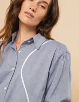 Camisa oversized de algodón, con botones a tono y cortes en ondas decorativos en el delantero.
