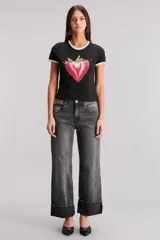 Remera blanca de calce slim, escote redondo y manga corta, con ribete negro en cuello y mangas. Estampa frontal de una frutilla roja con la frase "Bite Me".