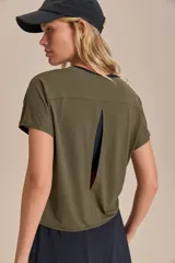 Remera deportiva verde militar de calce suelto, con mangas cortas, sisas desplazadas y abertura en la espalda. Confeccionada en tejido liviano y respirable con tecnología Quick Dry y Easy Care.