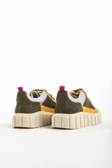 Zapatillas deportivas de cuero color beige con detalles en lila y amarillo.