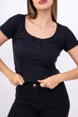 Remera corta de punto canalé color rosa, con cuello redondo y botones decorativos.