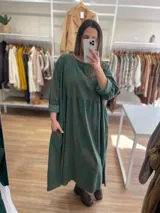 Vestido largo de pana fina color verde con estampado de flores marrones, corte oversize, mangas 3/4 y bolsillos laterales.