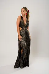 Vestido largo de fiesta con estampado abstracto en tonos dorados y negros. Tiene escote en V, corte en la cintura y aberturas laterales.