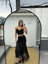 Pollera larga irregular de encaje color marrón oscuro, con forro corto.