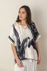 Blusa italiana color natural con estampado de hojas en tonos grises. De calce holgado y mangas cortas.