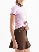 Minifalda de denim negro con cinco bolsillos tradicionales y un volado en el ruedo.