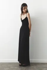 Vestido largo negro de escote fluido y tirantes finos ajustables.