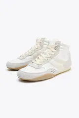 Botín deportivo blanco con detalles en beige y suela color caramelo. Cierre con cordones y puntera redonda.