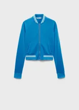 Chaqueta deportiva azul con cierre frontal, cuello redondo y terminaciones con rayas blancas en cuello, puños y ruedo.
