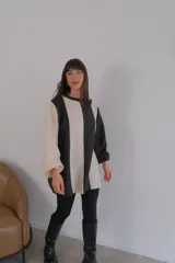 Buzo de mangas largas con diseño de bloques de color en marrón, gris y beige.