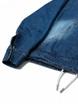 Canguro de jean azul con capucha, corte boxy y cordón ajustable en la cintura.