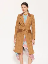 Trench marrón claro con broderie y detalles en cuero marrón, con hombreras, bolsillos plaqué con tapa de cuero y lazo para ajustar en cintura.