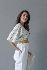 Top cruzado escotado de tusor de algodón con estampado de lunares verdes, cintura elastizada y manga corta holgada.