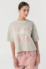 Remera color gris claro con estampa frontal de un gato blanco y texto en color rosa.